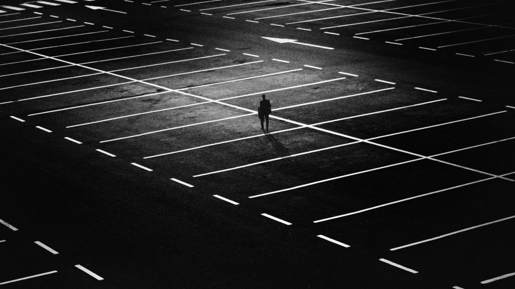 man-standing-on-parking-lot-163772-1024x576